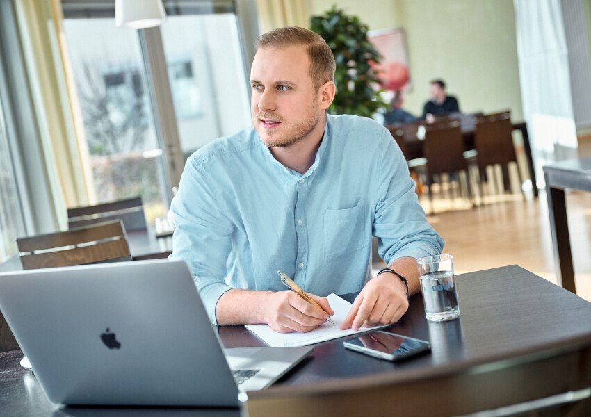 OOWV Mitarbeitender in der Kantine mit Laptop